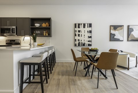 A modern kitchen with a dining table and chairs.