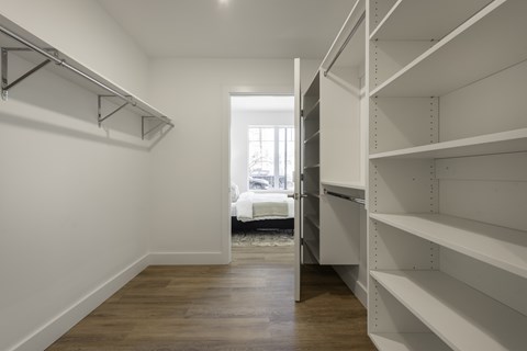 A long hallway with white walls and wood floors.