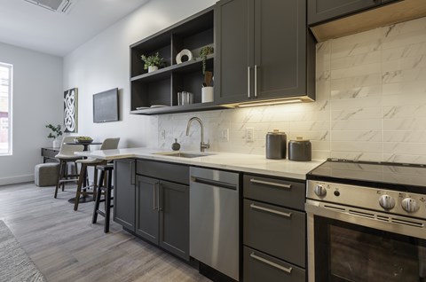 A kitchen with a marble backsplash and dark wood cabinets.