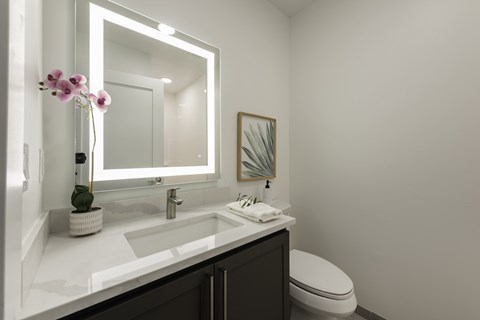 A bathroom with a white sink and a toilet.