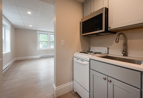 A kitchen with a white oven and microwave.
