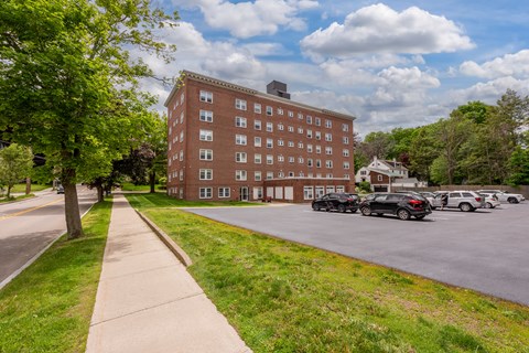 A large red brick building with a parking lot in front.