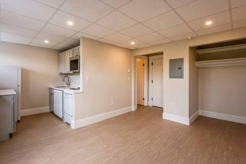 A kitchen area with a refrigerator, dishwasher, and cabinets.