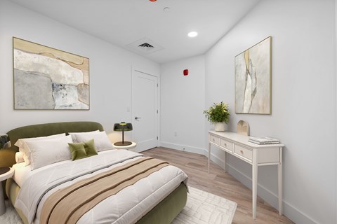 A bedroom with a bed, nightstand, and a painting on the wall.