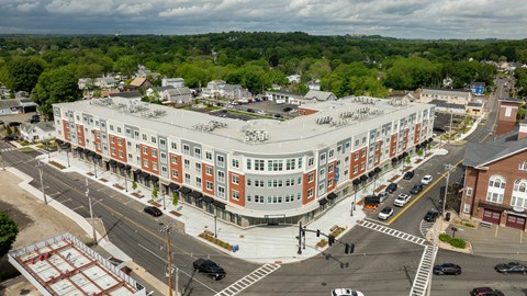 A large building with a red and white striped facade sits in the middle of a busy intersection.