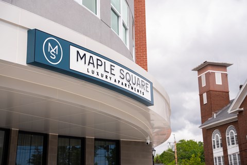 A sign for Maple Square Luxury Apartments is displayed above the entrance.