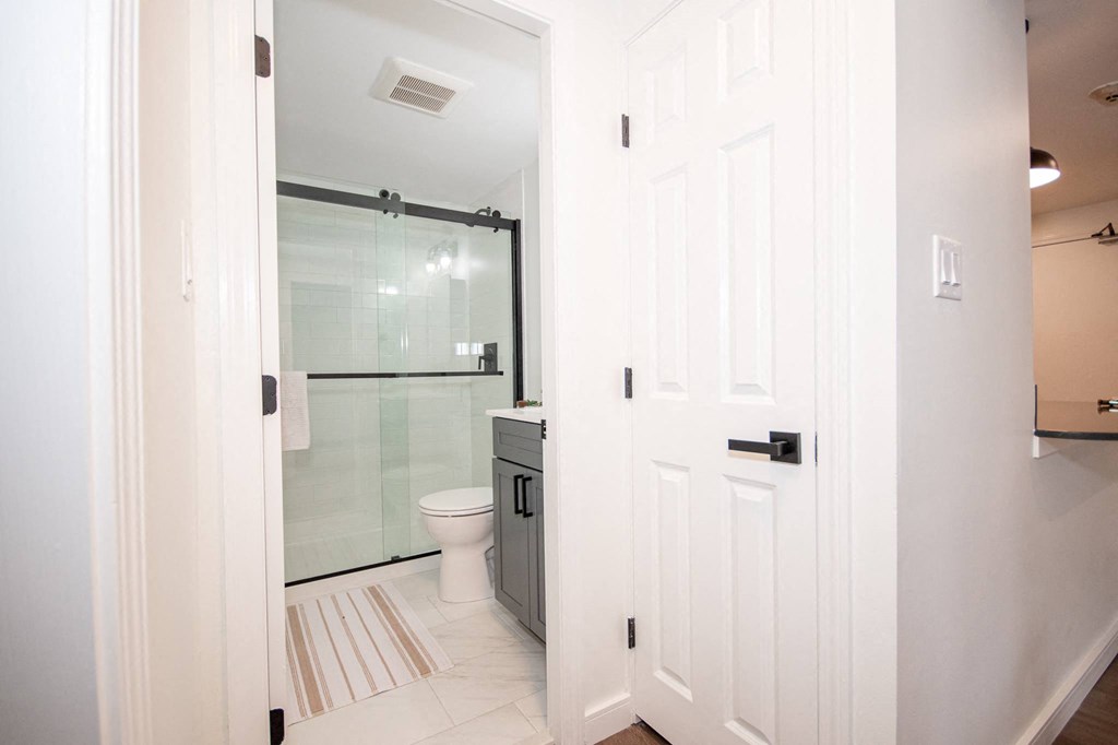 a white bathroom with a shower and a toilet