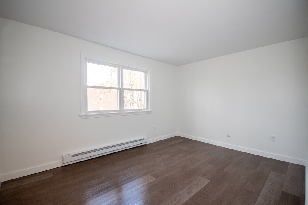 an empty room with white walls and a window