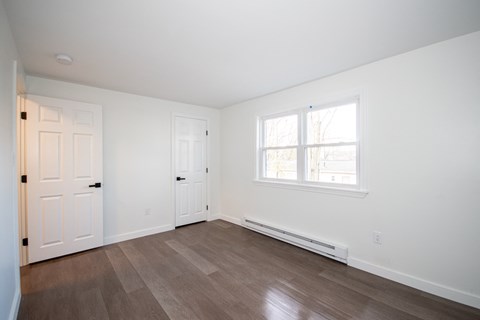 an empty room with white walls and a window and a door