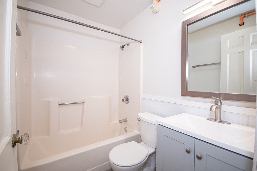 a bathroom with a white bathtub and a white toilet next to a white sink with a