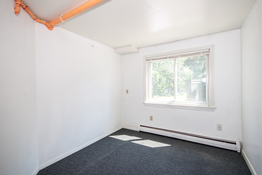 a small room with white walls and a large window