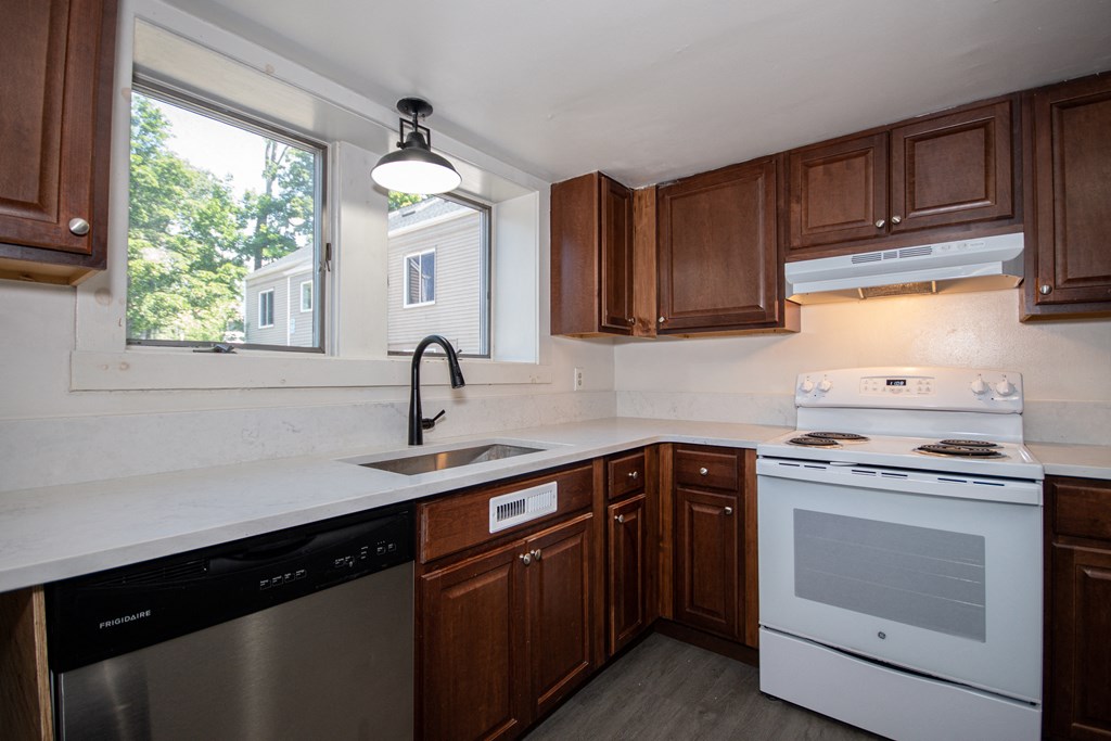a kitchen with dark wood cabinets and white appliances