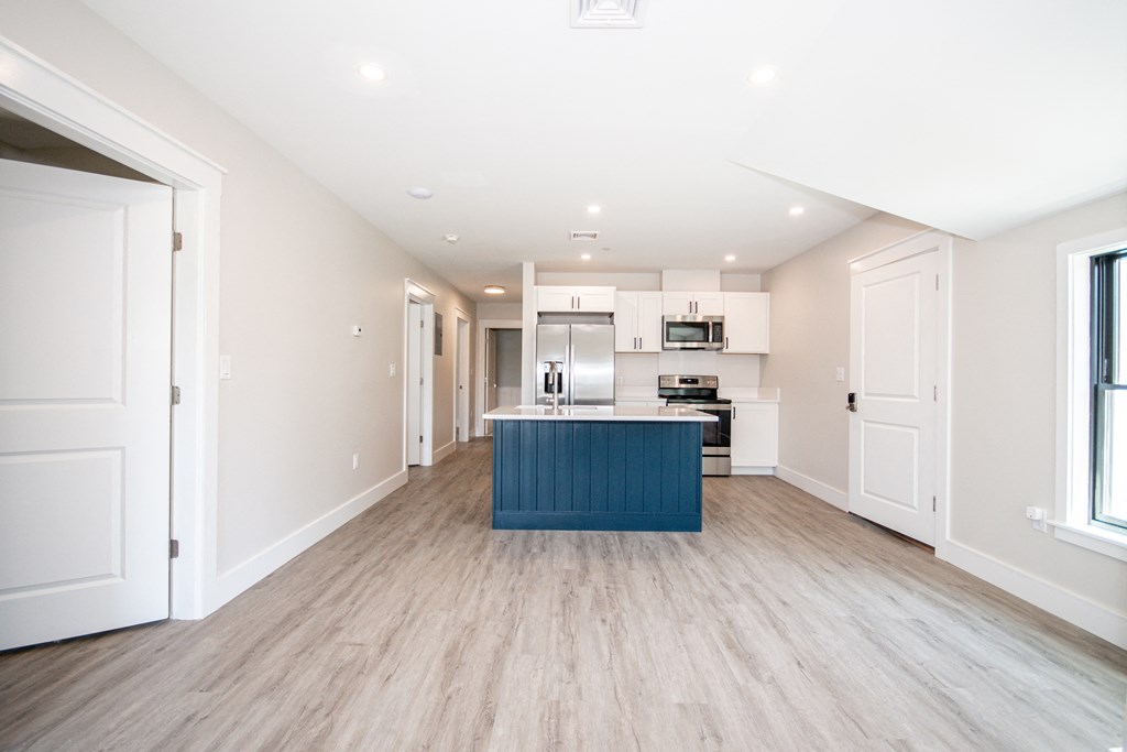 a kitchen with white cabinets and a blue island