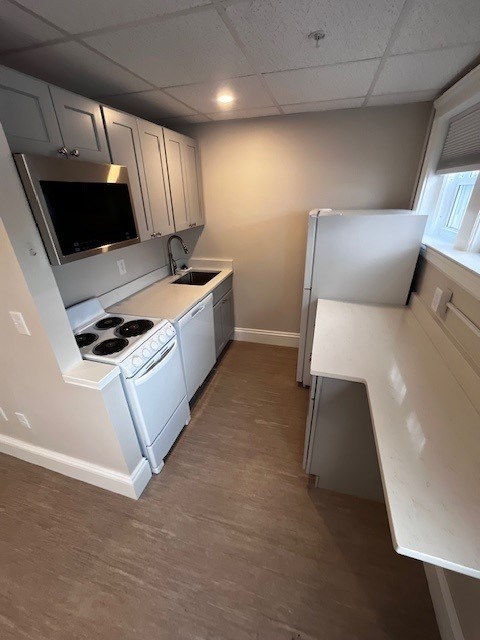 A small kitchen with a stove top oven and microwave.