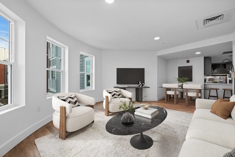 A living room with a black coffee table and white furniture.