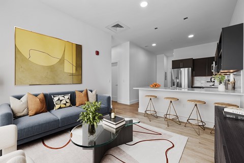 A modern living room with a blue couch and a glass coffee table.