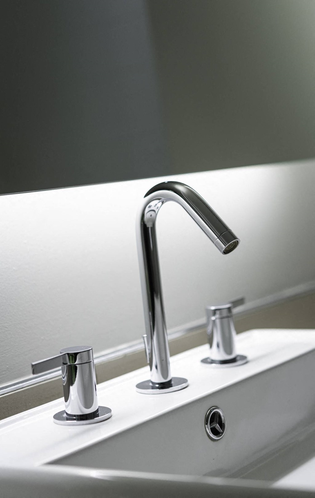 a bathroom sink with a chrome faucet and a mirror
