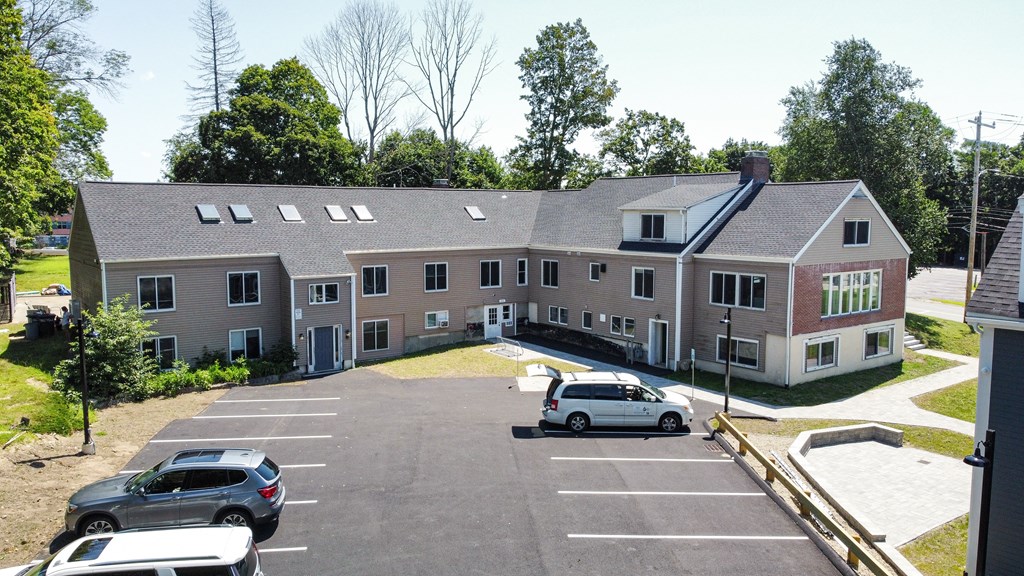 a large apartment complex with cars parked in front of it
