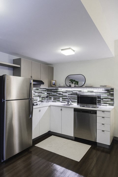 a kitchen with white cabinets and a stainless steel refrigerator