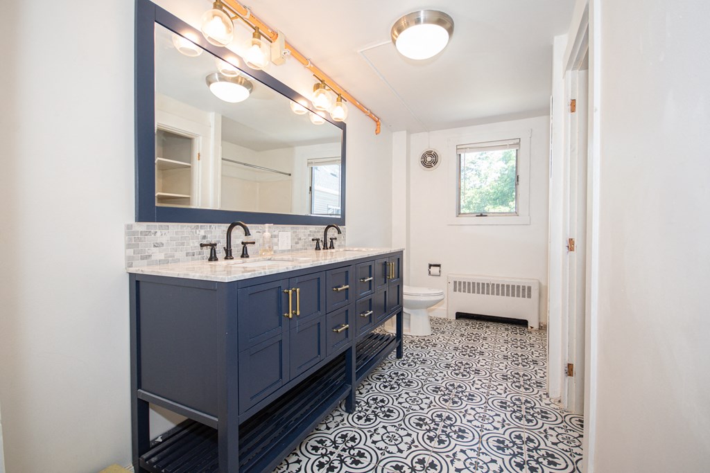 a bathroom with a blue vanity and white walls