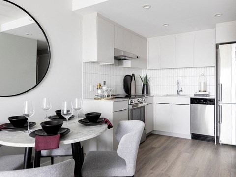 A modern kitchen with a dining table set for two.
