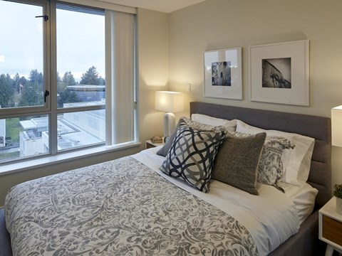 A bedroom with a large bed and a window overlooking a parking lot.
