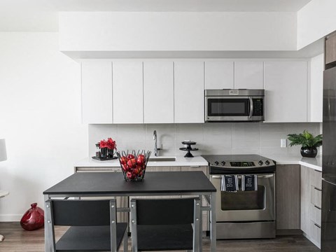 A modern kitchen with a black table and stove.