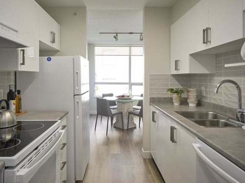 A kitchen with white cabinets and a black stove top.