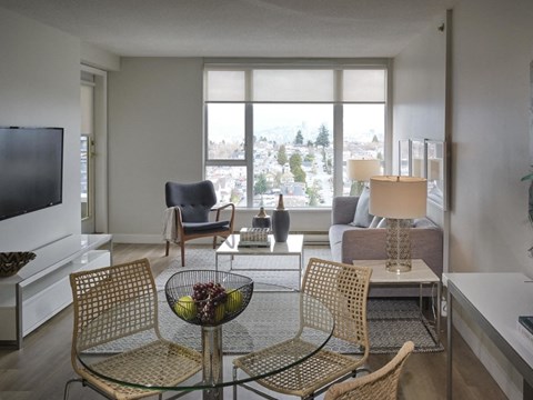 A living room with a glass table and chairs.