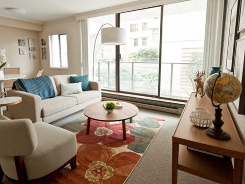 A living room with a couch, chairs, a table, and a globe on a table.