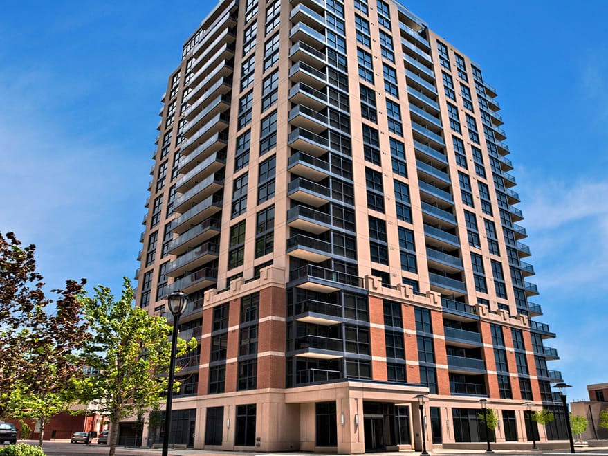 a tall building with balconies and a blue sky in the background