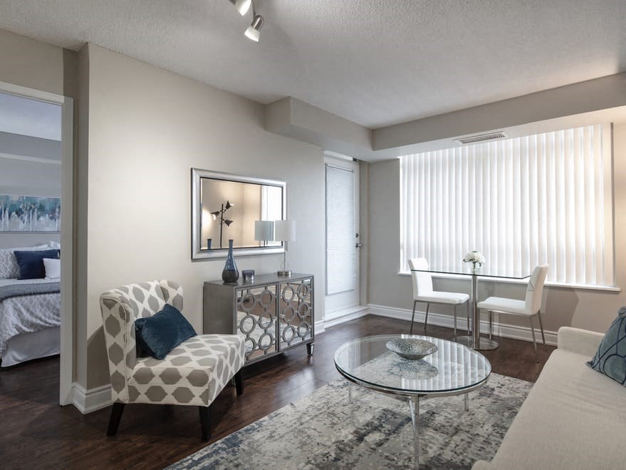 a living room with a couch and a chair in front of a window