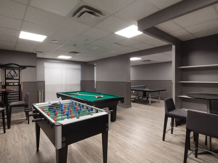 a games room with two pool tables and a ping pong table