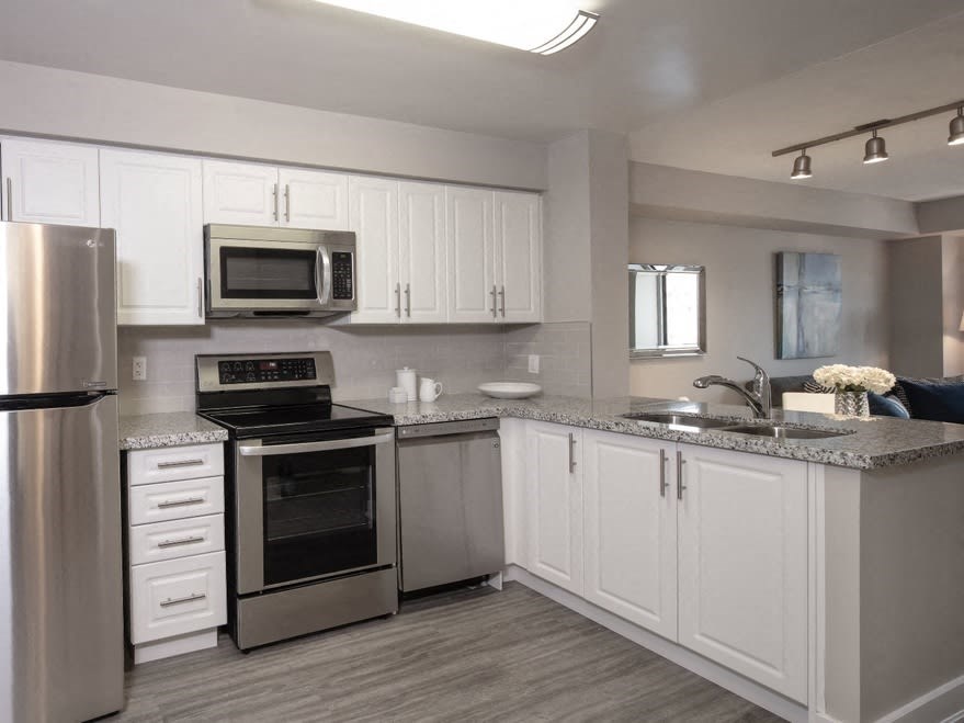 a kitchen with white cabinets and stainless steel appliances