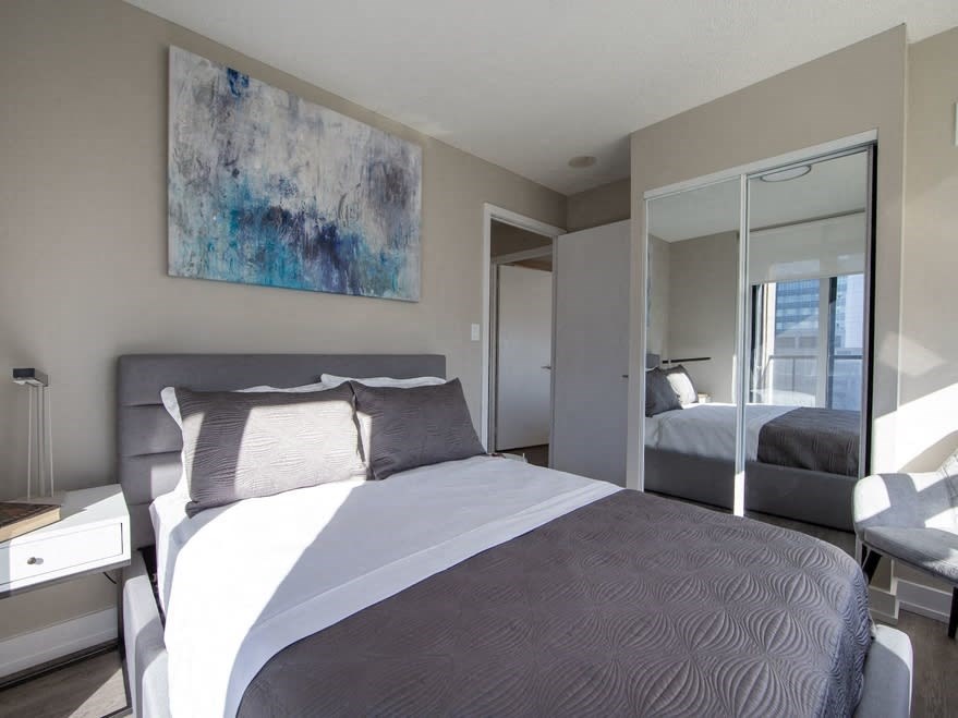 a bedroom with a large bed and a large mirror