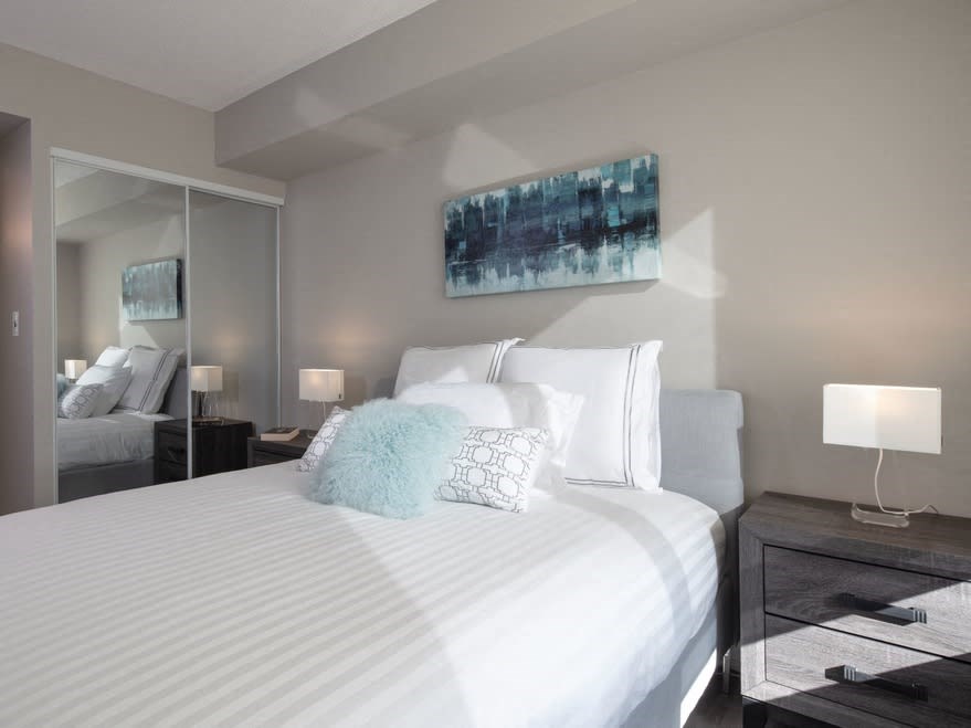 a bedroom with a large bed and a mirror