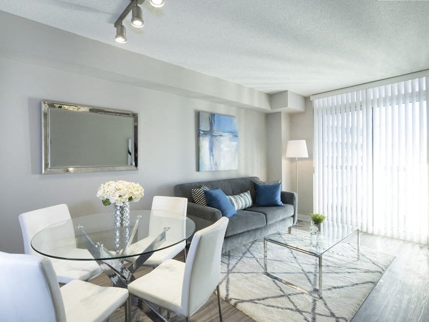 a living room with a glass table and chairs