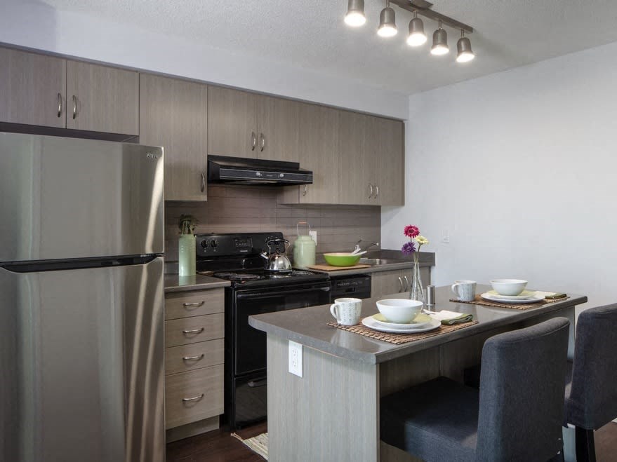 a kitchen with a refrigerator freezer next to a stove top oven