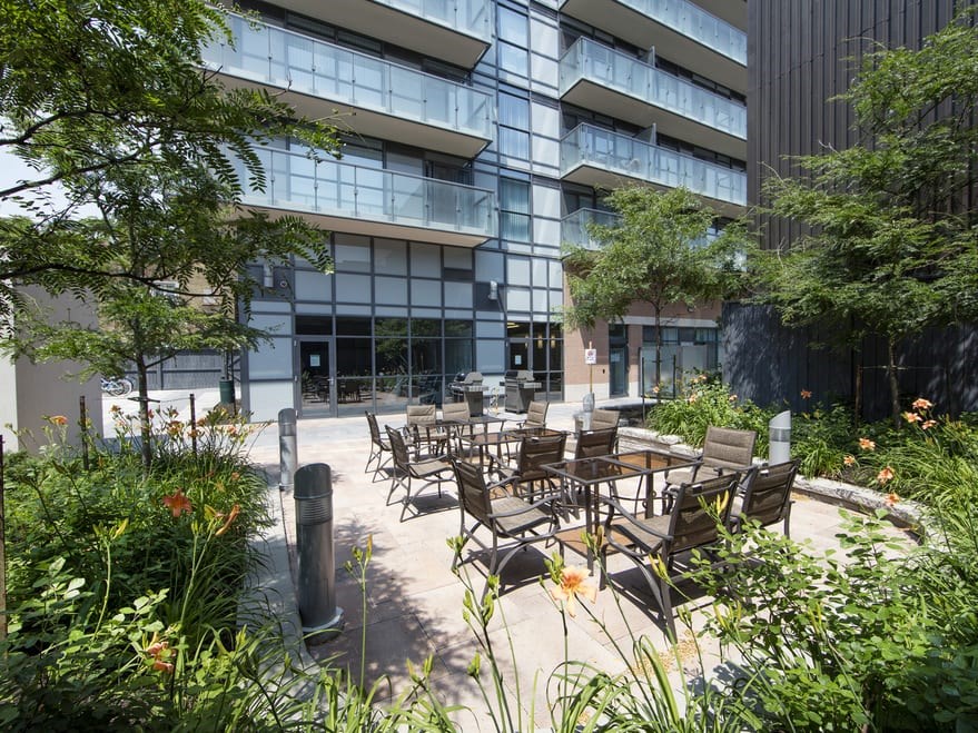 a courtyard with tables and chairs in front of a building