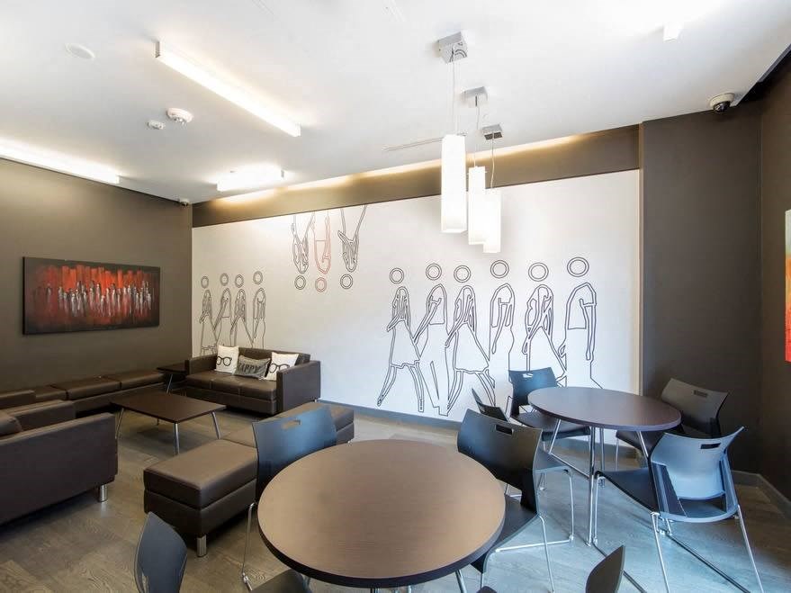 a room with tables and chairs and a mural on the wall