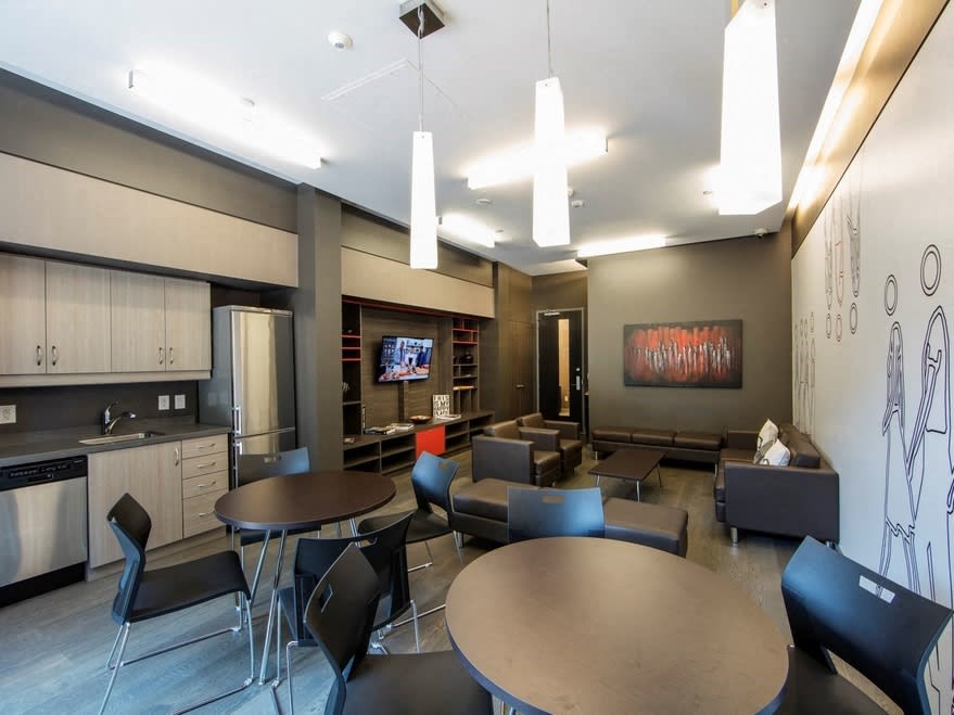 a lounge area with tables and chairs and a television in the background