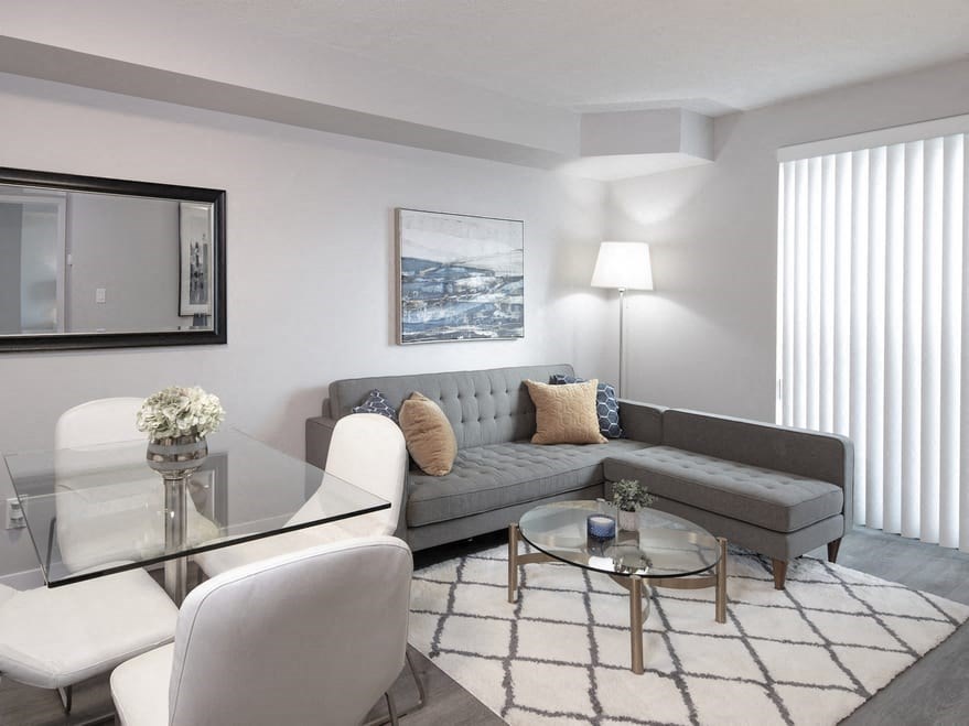 a living room with a gray couch and a glass coffee table