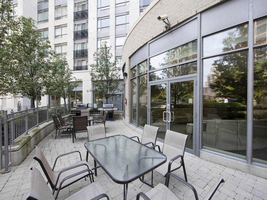 a patio with a table and chairs in front of a building