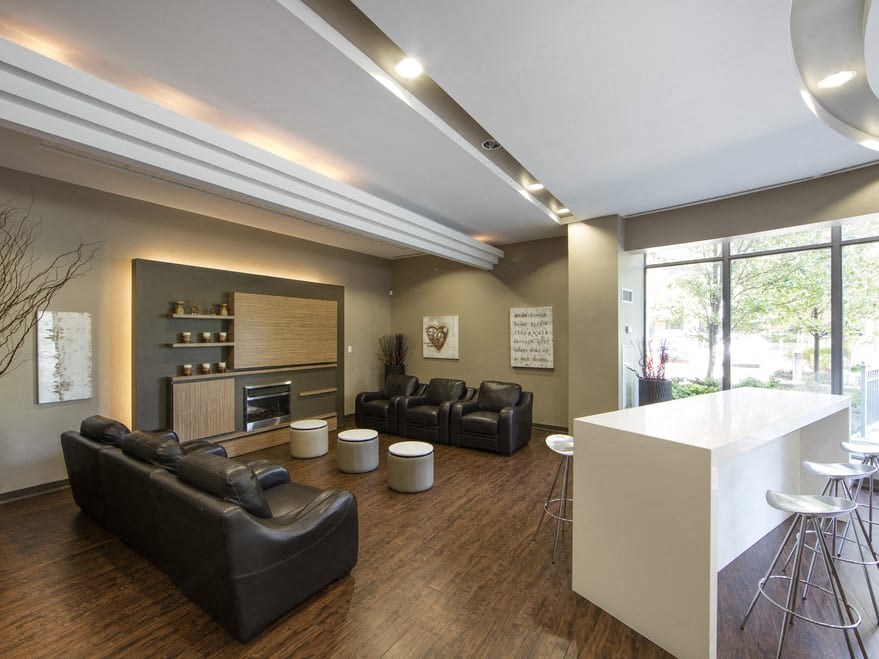 a living room with leather couches and stools