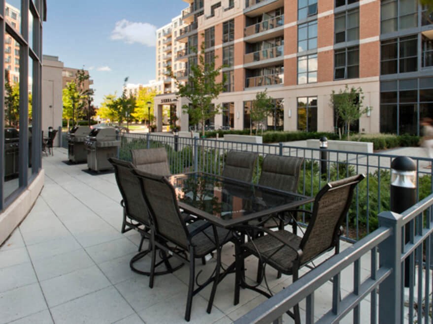 a patio with a table and chairs in front of a building