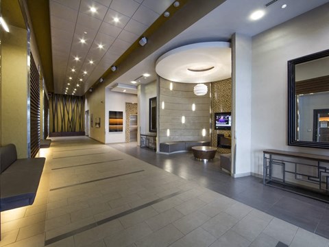 a lobby with a tv and a couch in front of a fire place