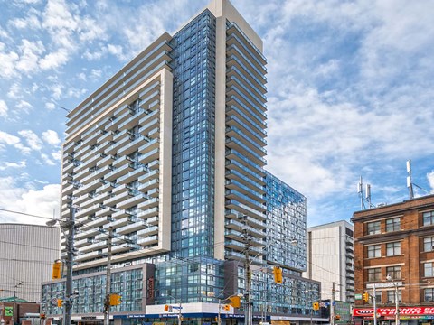 a tall building with many windows and a blue sky in the background