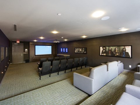 a large room with couches and chairs and a projection screen