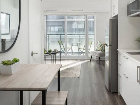 A modern kitchen with a wooden table and chairs.
