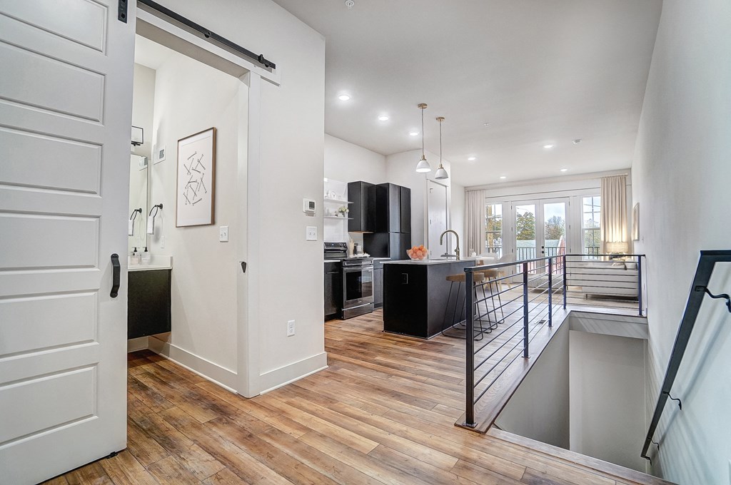 an open kitchen and living room with a staircase leading up to it